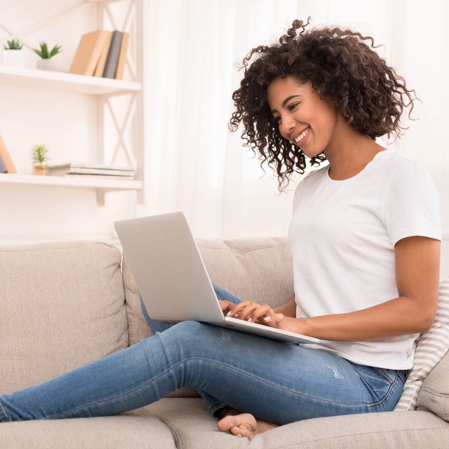 Girl Sitting on Couch with laptop.
